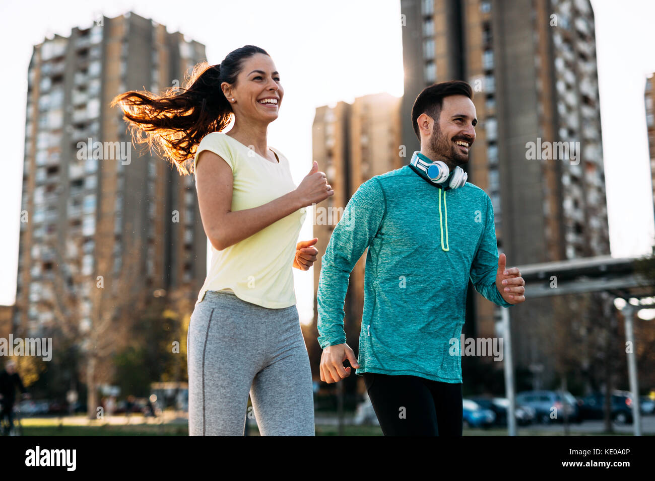Runnuing Outside View Young attractive couple running outside on sunny day Stock Photo - Alamy