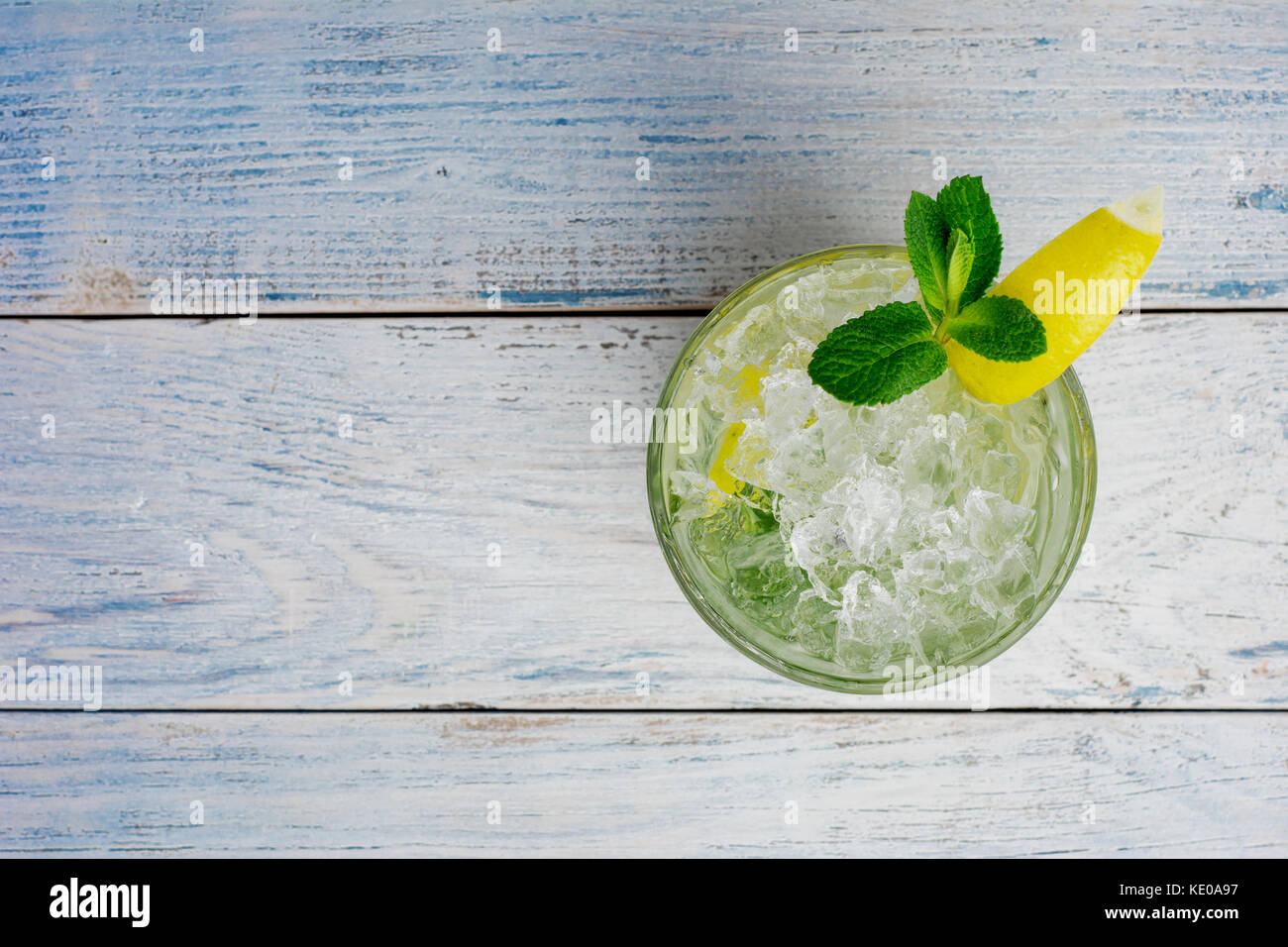 Alcohol mojito cocktil bar long drink fresh tropical beverage top view copy space highball glass, with rum, spearmint, lime juice, soda water and ice on white concrete table. Stock Photo