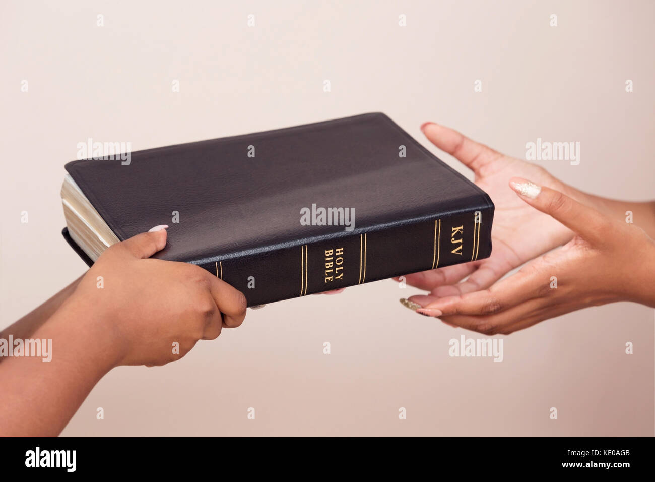 Handing A Bible To A Person Who Is Interested In Becoming A Christian Stock Photo