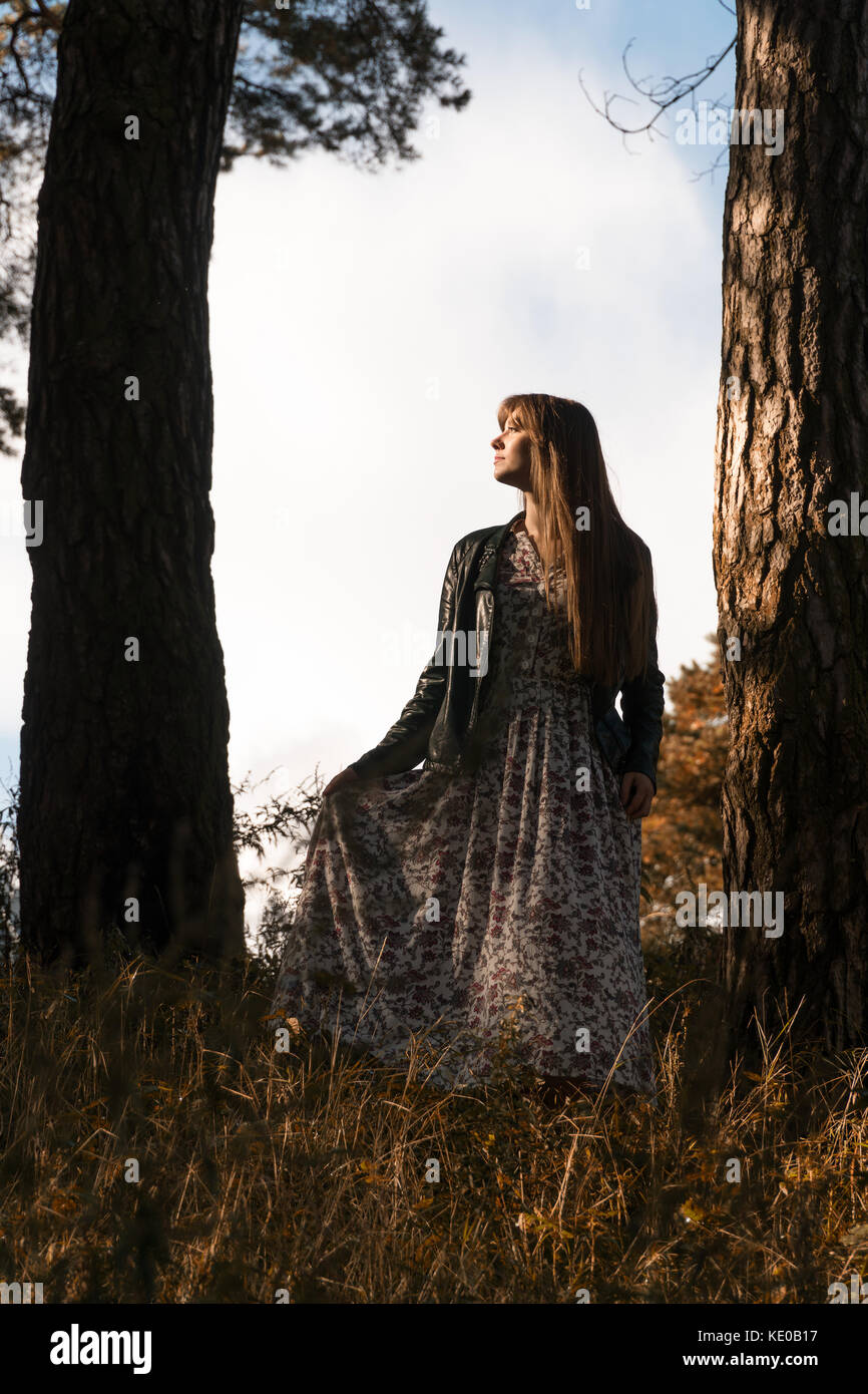 fashion photo of young beautiful woman posing in forest near big tree ...