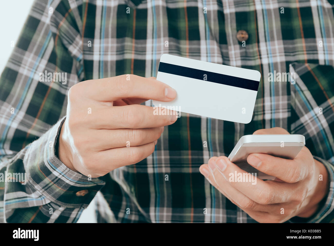 young man holding credit card and use smartphone for pay or shopping online concept Stock Photo