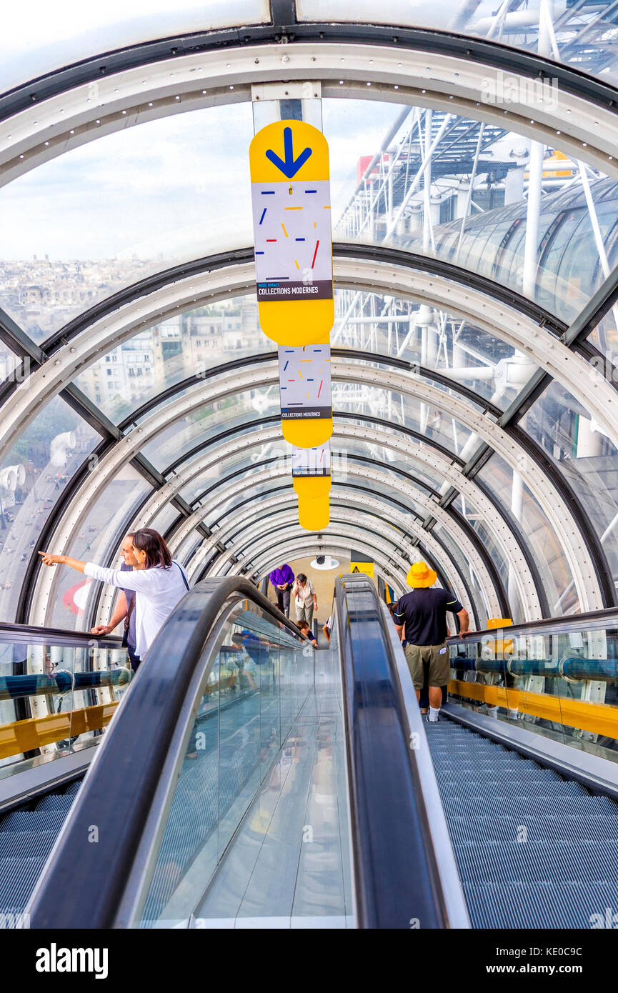 Tourists decent the long escalators at the Pompidou Centre in Paris Stock Photo