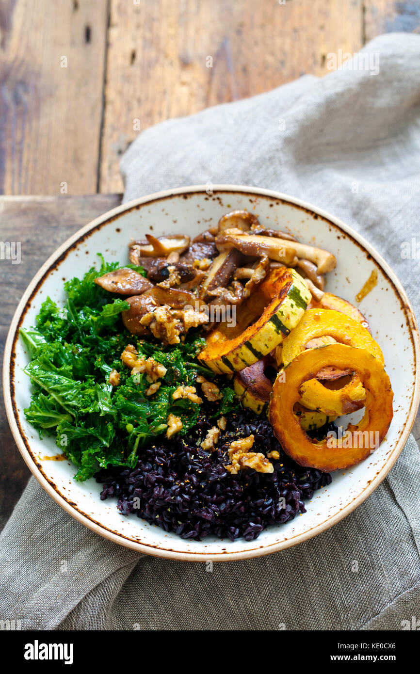 Delicata winter squash with black rice, shiitake mushrooms and massaged kale Stock Photo