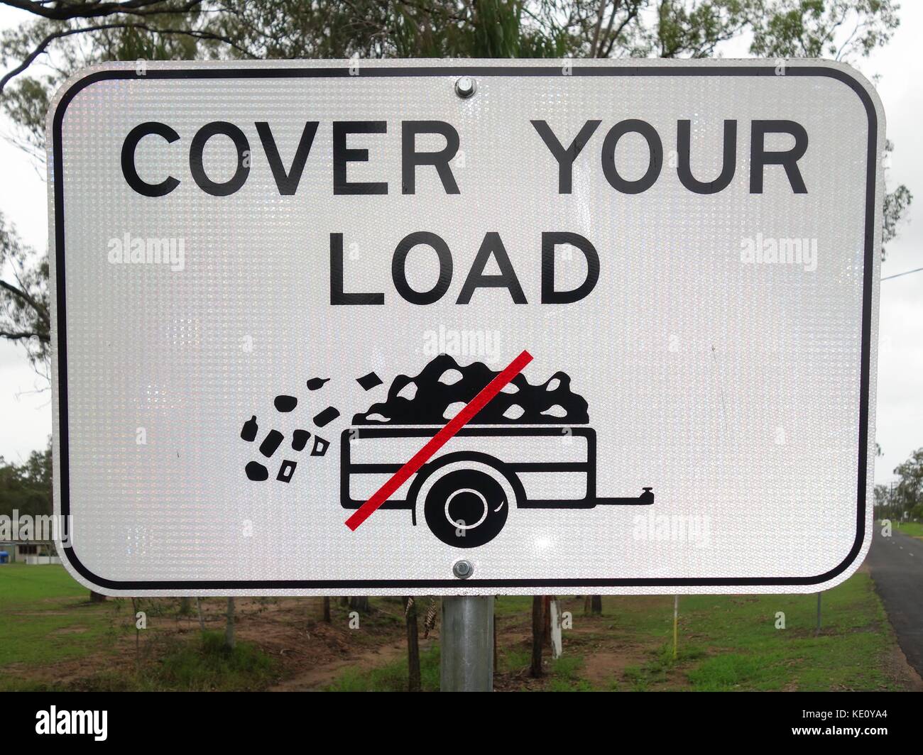 A road sign requiring any trailer being towed by a vehicle to cover its load in Australia Stock Photo