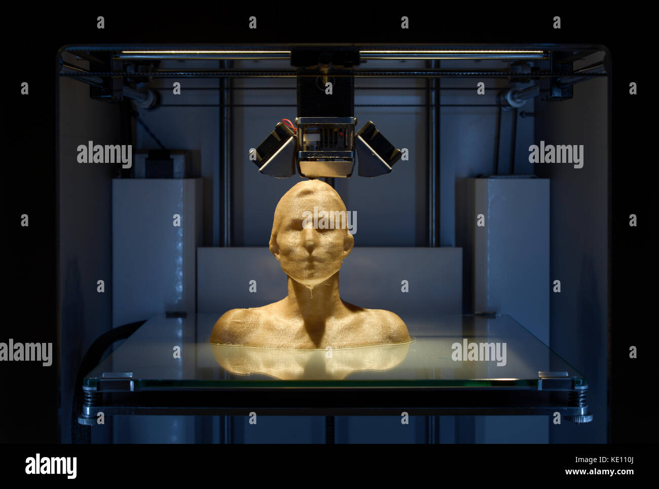 3D printer printing a female bust with golden PLA filament, Polylactide (PLA) is a biodegradable polyester derived from plants.Close Up, CU, frontal Stock Photo