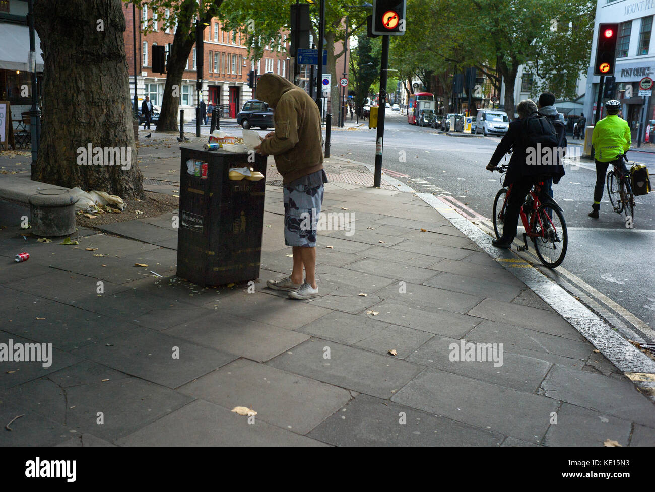 Rough Sleeper finding food in rubbish bin, Islington,London,England. Oct 2017 Stock Photo