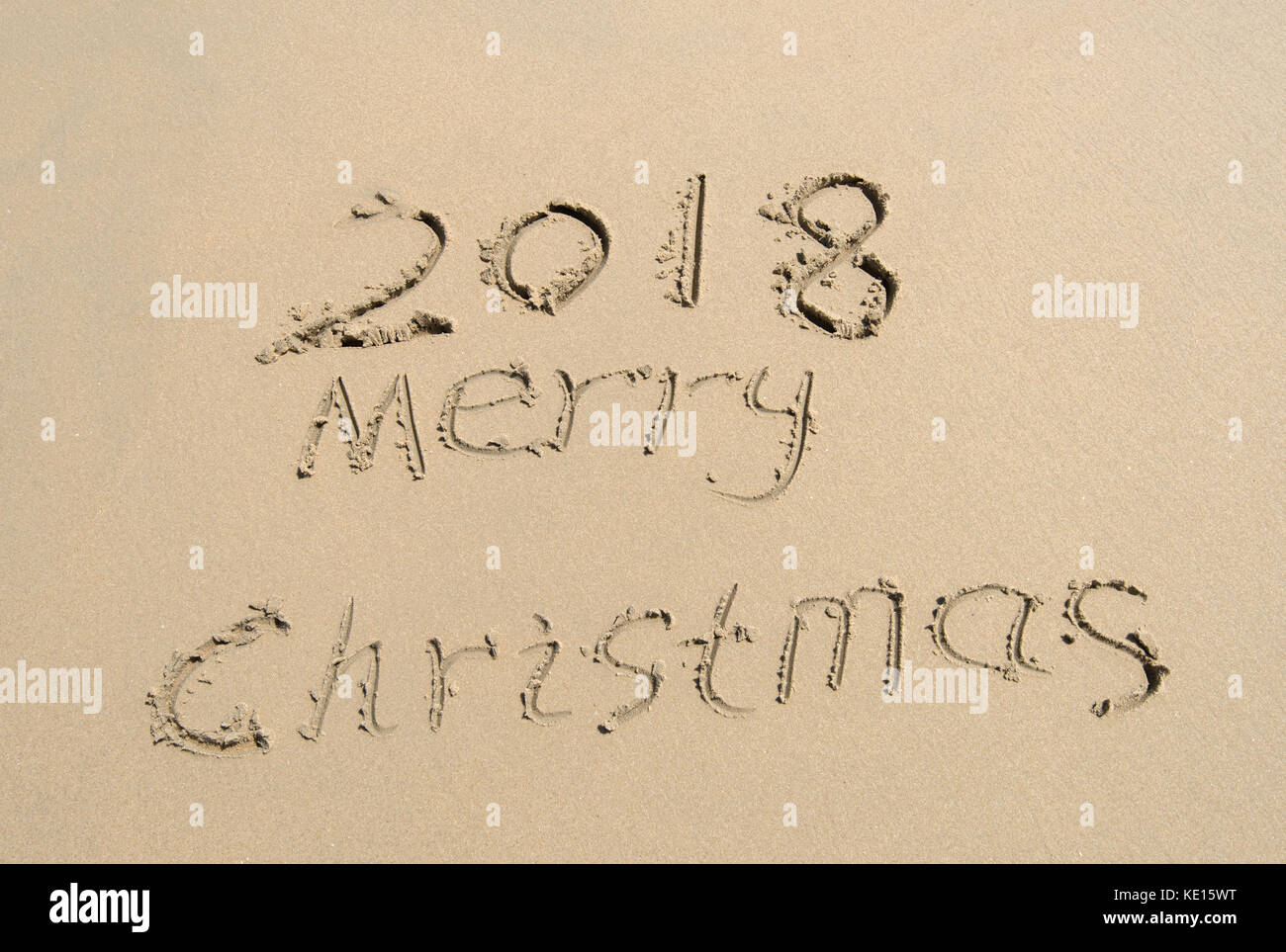 2018 Merry Christmas handwritten in sand on beach Stock Photo