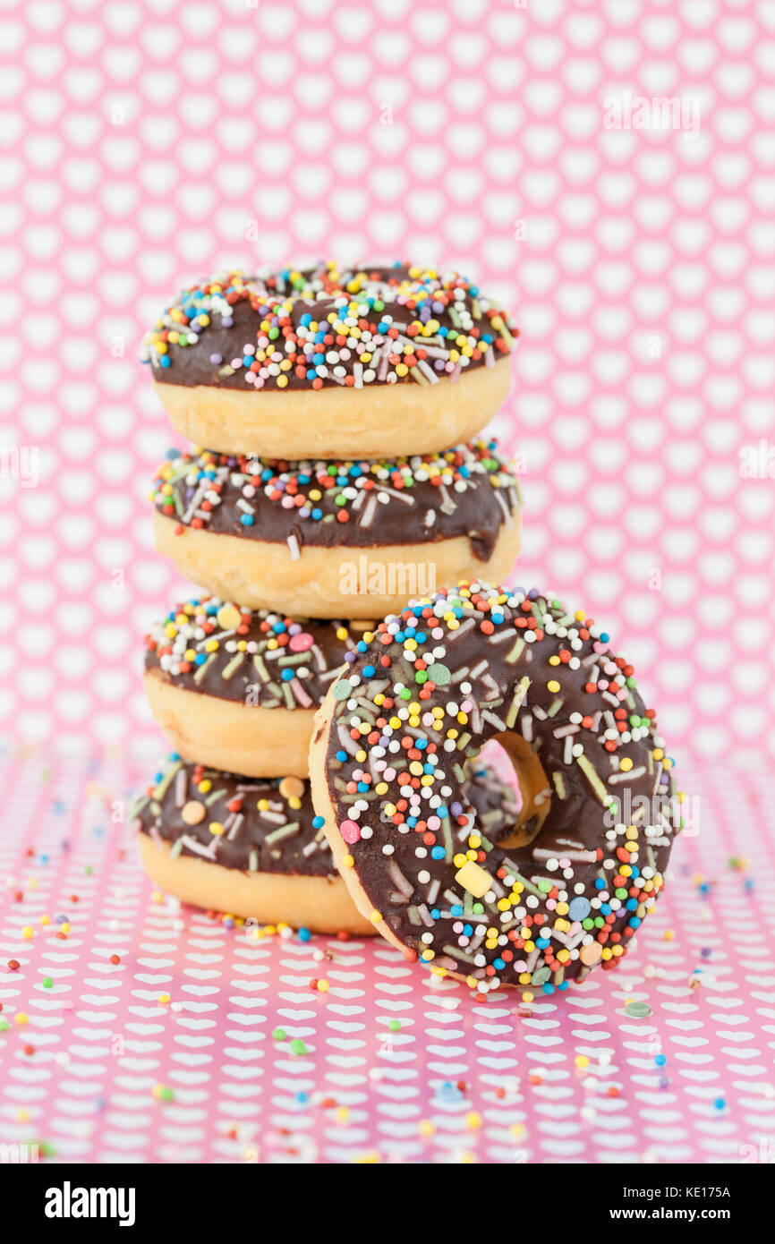 Stack of donuts with chocolate frosting and colorful sprinkles Stock Photo
