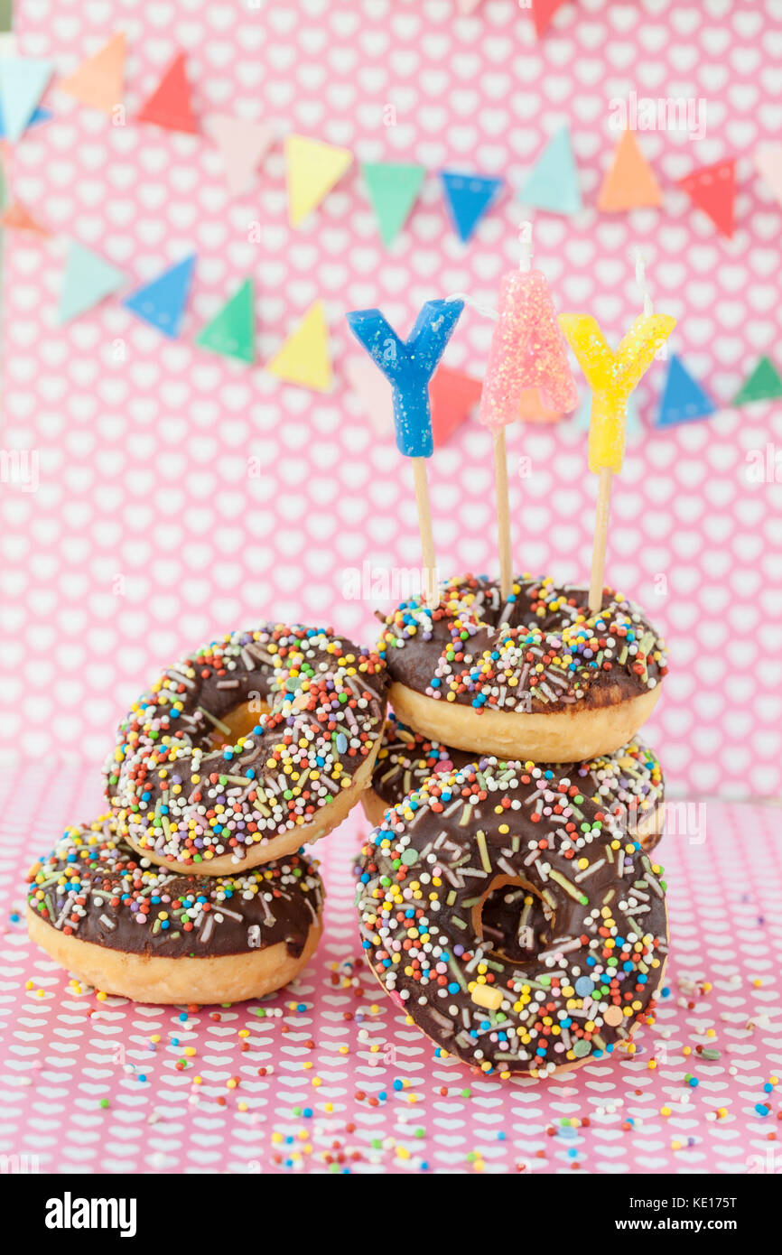 Stack of donuts with chocolate frosting and colorful sprinkles Stock Photo