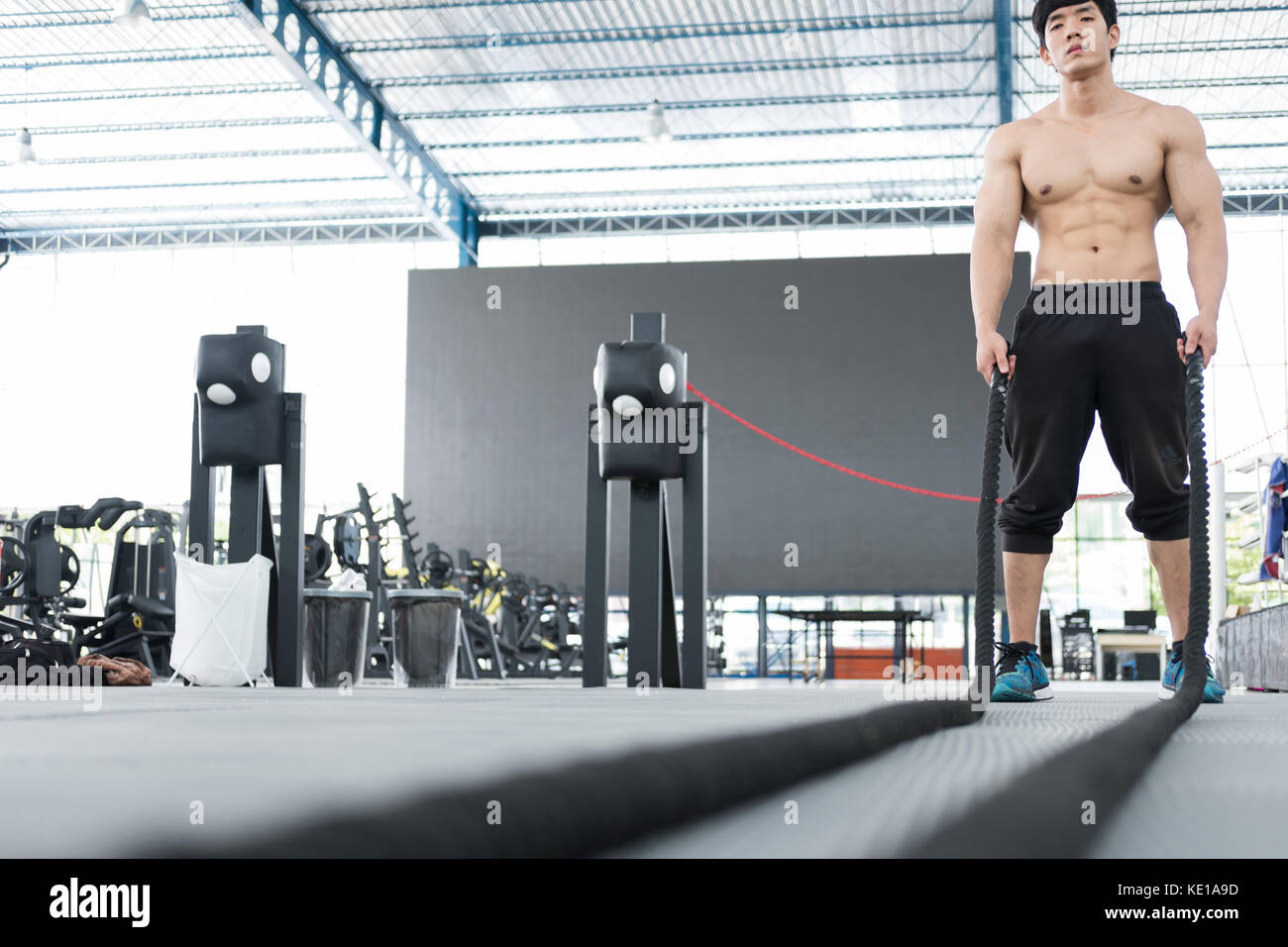 Execute Rope young man execute exercise in fitness center. male athlete training ...