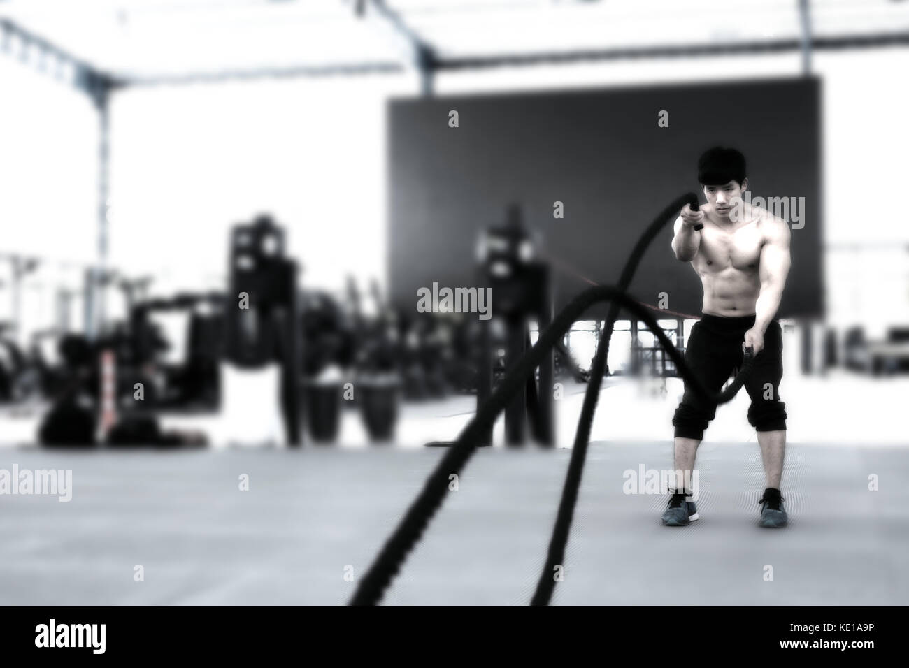 Execute Rope young man execute exercise in fitness center. male athlete training ...