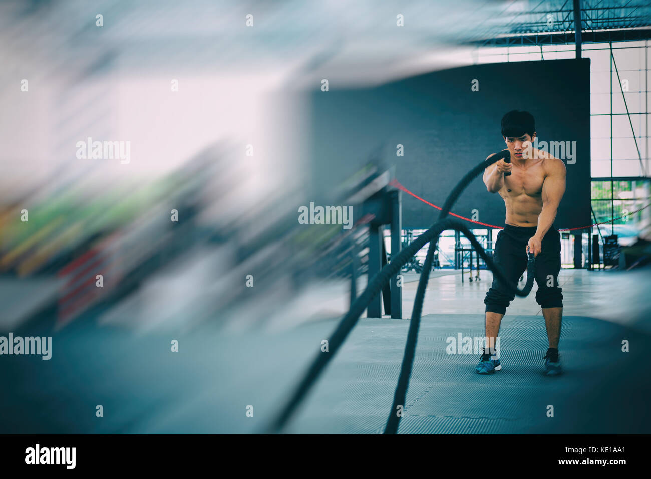 Execute Rope young man execute exercise in fitness center. male athlete training ...