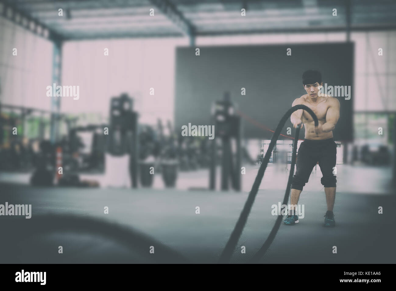 Execute Rope young man execute exercise in fitness center. male athlete training ...