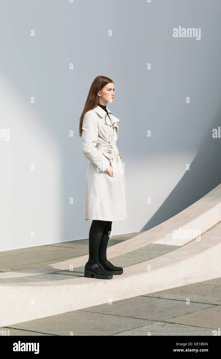 Woman standing in coat posing Stock Photo