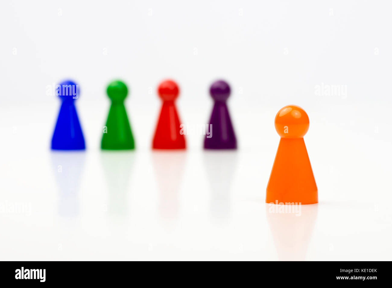 Close-up photo of a group of different-colored pieces in different positions on a white background - applicable to the team view Stock Photo