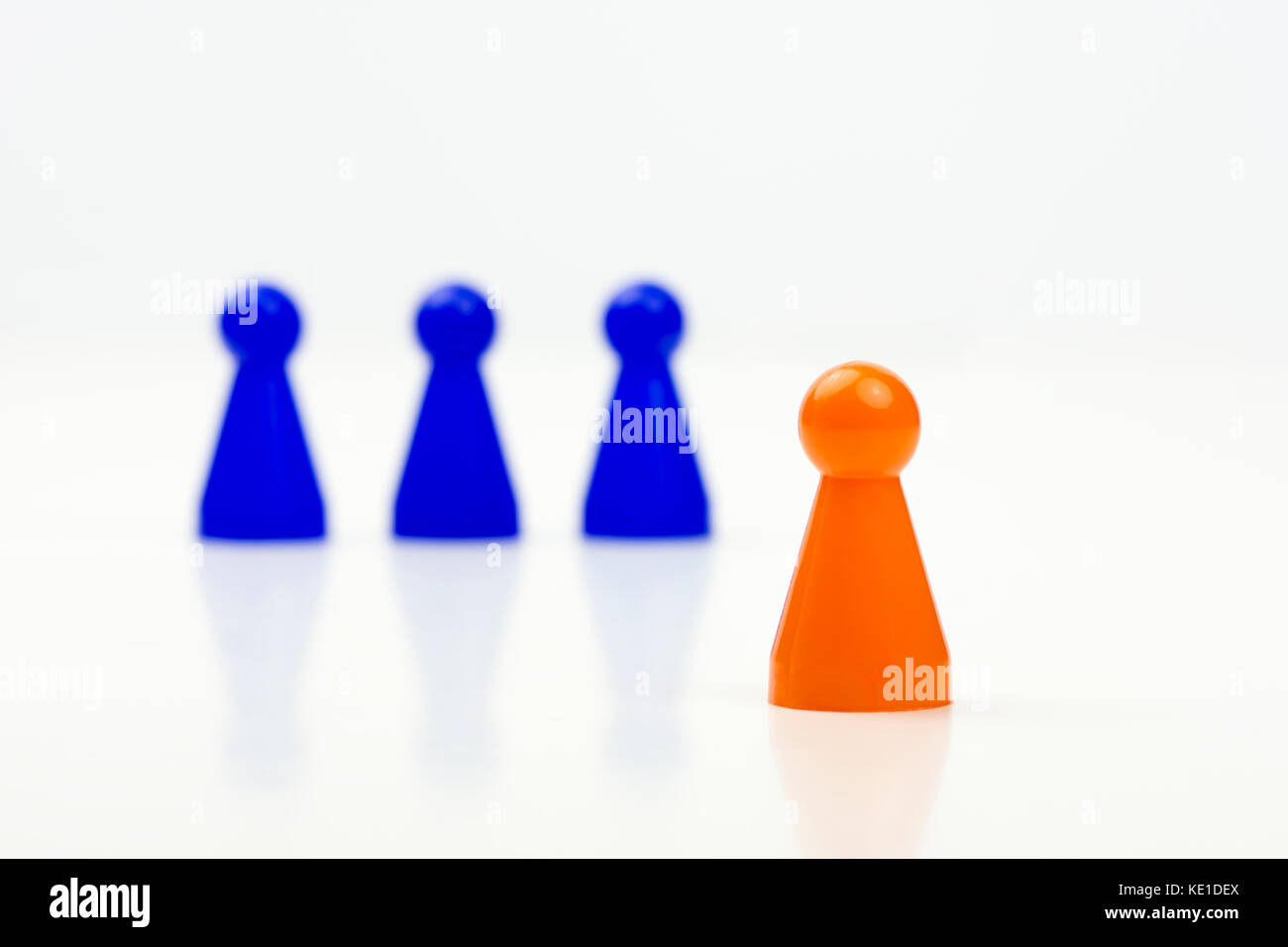 Close-up photo of a group of different-colored pieces in different positions on a white background - applicable to the team view Stock Photo