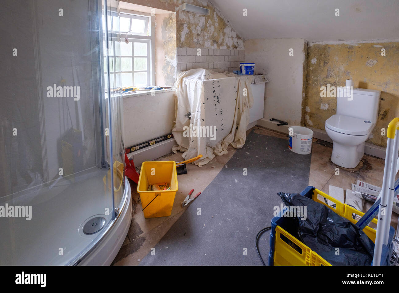 Decoration of bathroom after refitting in old cottage, Gloucestershire