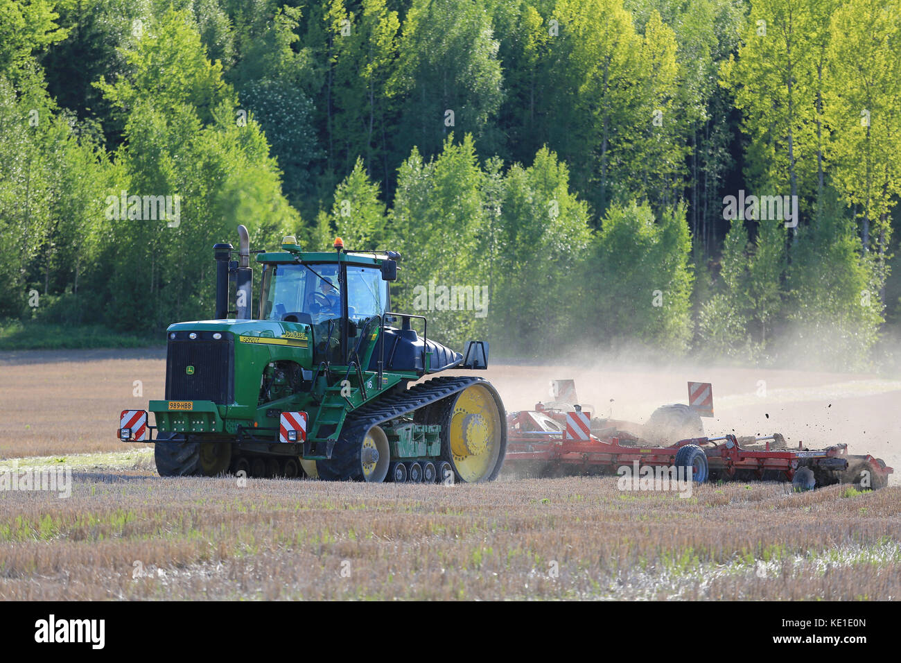 SALO, FINLAND - MAY 27, 2016: John Deere 9520T tracked tractor and cultivator on stubble field at spring in South of Finland. Stock Photo