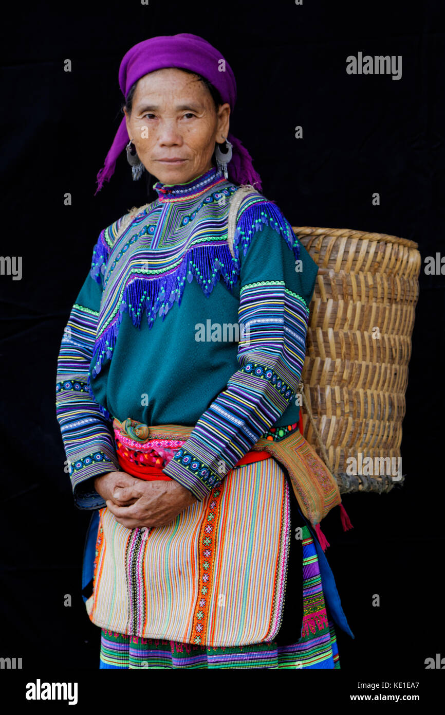 SIN CHENG, VIETNAM, October 26, 2016 : Woman with a bag in front of a black sheet. HMong women of North Vietnam wear their best traditional clothes wh Stock Photo