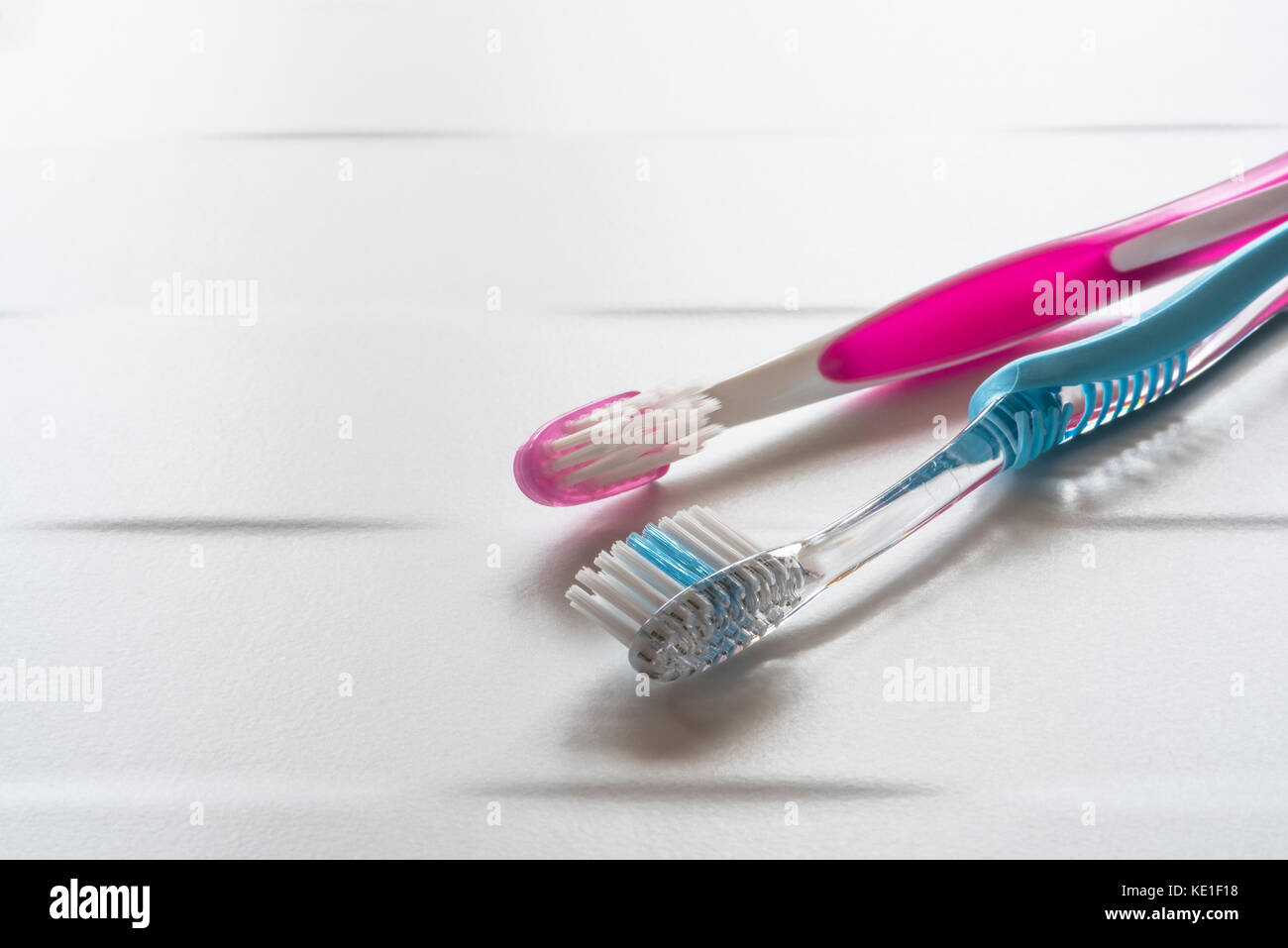 His and hers pink and blue toothbrushes. Stock Photo