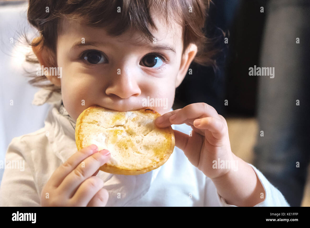 baby child eat carbohydrates -  newborn eating face closeup portrait - unhealthy diet for kids Stock Photo