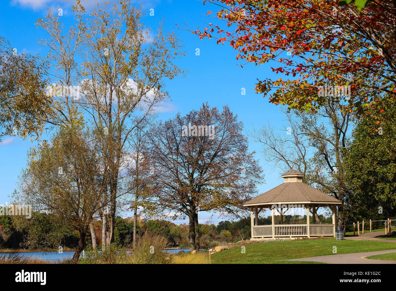 A beautiful landscape with a gazebo in a park and a lake with lots of ...