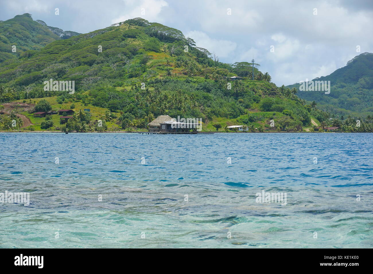 South Pacific island Huahine in French Polynesia coastline with a pearl oyster farm over water in the lagoon Stock Photo