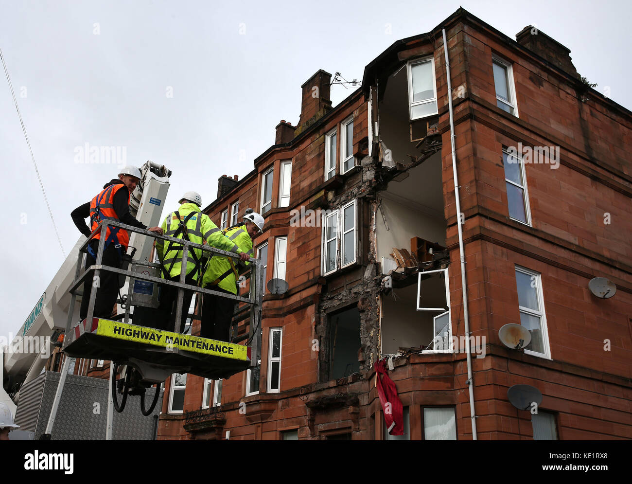 Workmen survey the damage to a block of flats in Crosshill, in the south side of Glasgow, after part of the front was brought down in high winds as Storm Ophelia sweeps across Scotland. Stock Photo