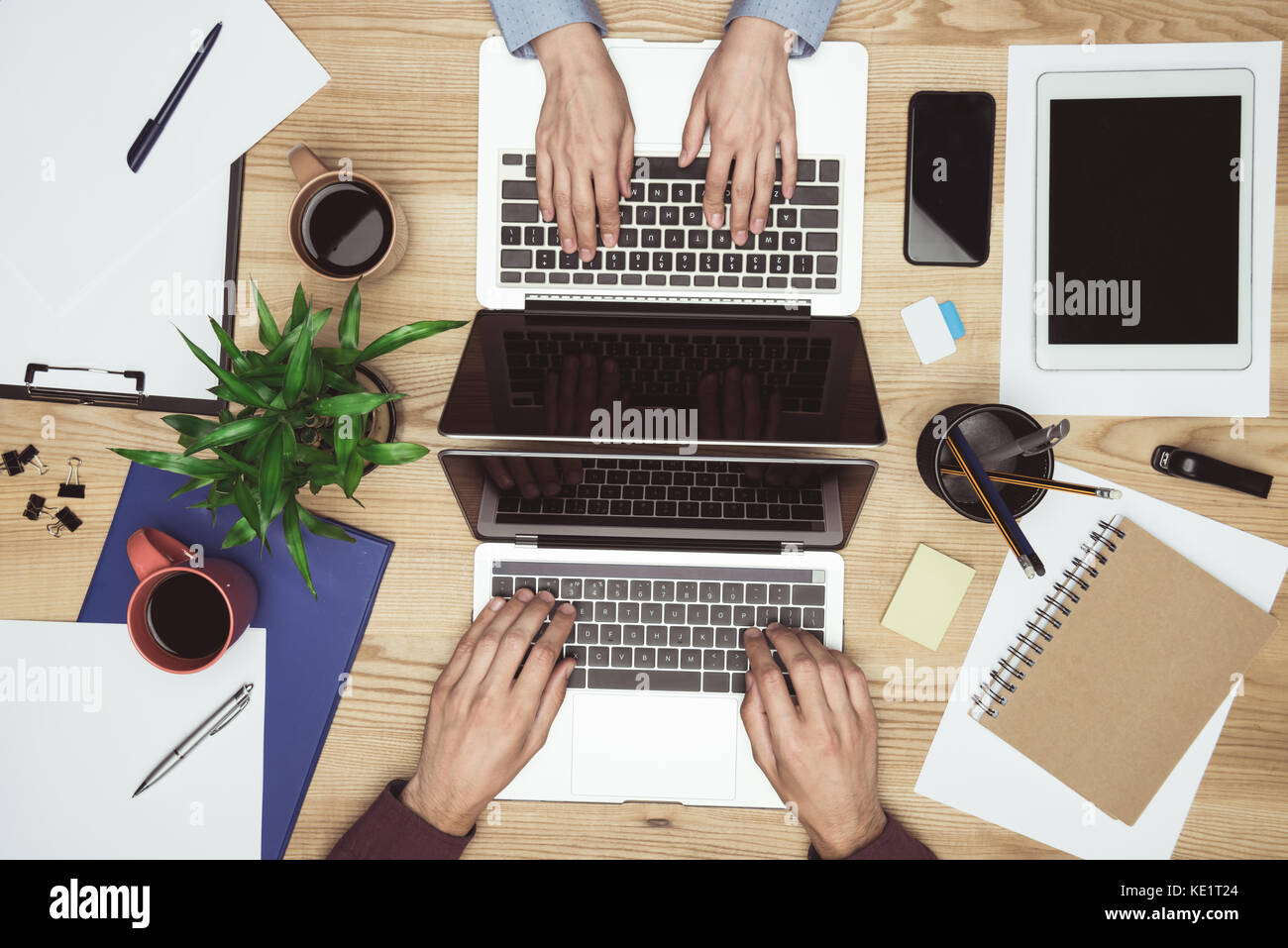 https://c8.alamy.com/comp/KE1T24/top-view-of-businesspeople-working-and-typing-on-laptops-at-workplace-KE1T24.jpg