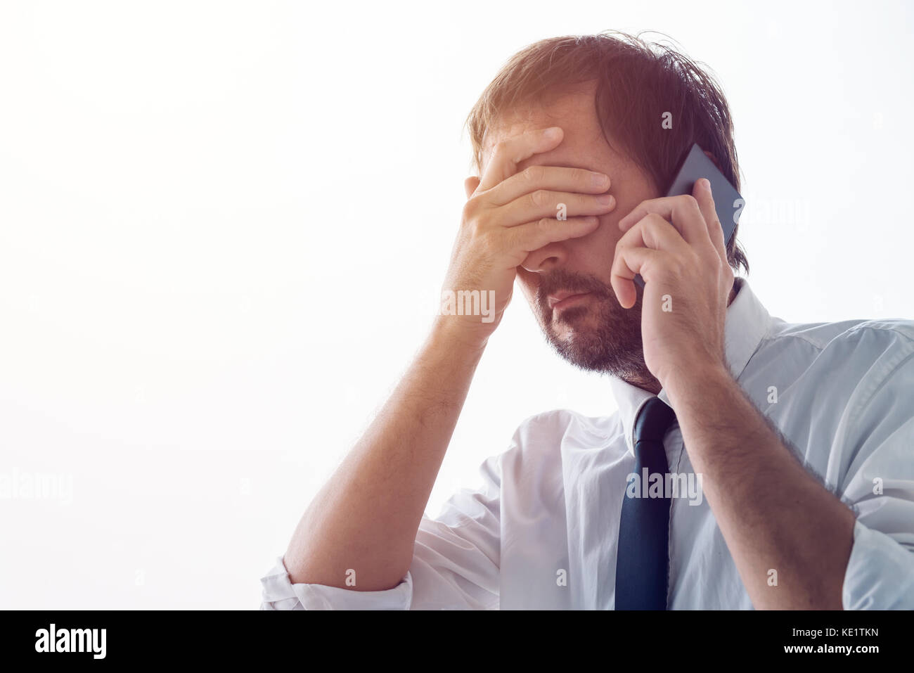 Forgetful businessman reminded over the phone about business meeting is about to be late. Stock Photo