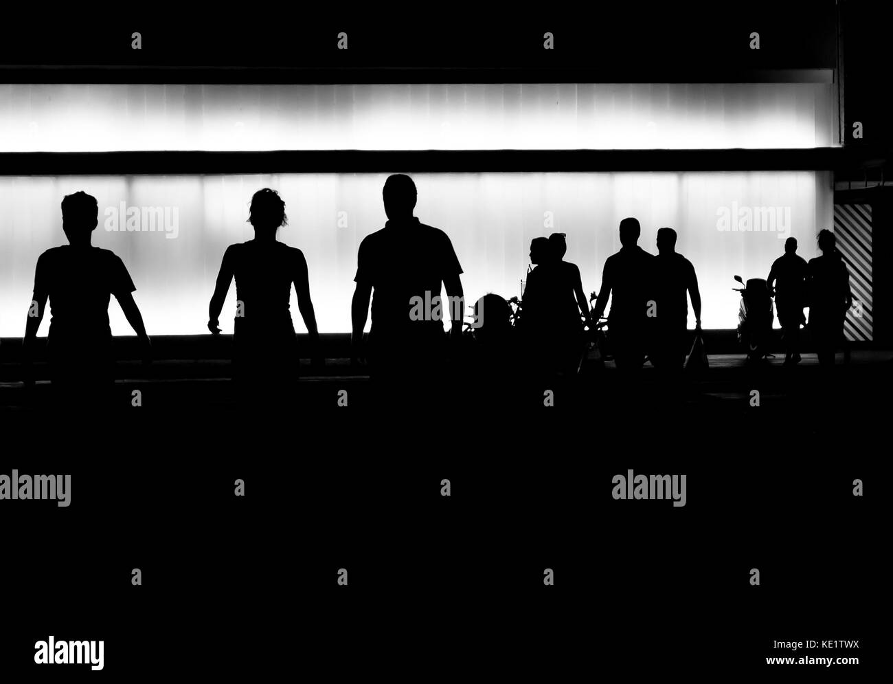 Silhouettes of young people getting out of the building Stock Photo