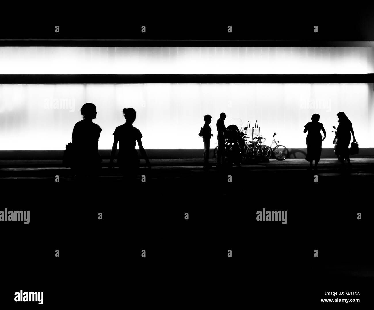 Silhouettes of  people getting out of the building in the night Stock Photo