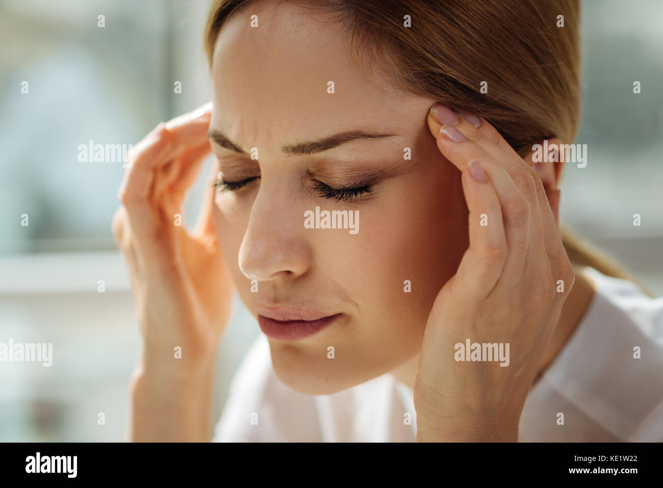 Tired office worker massaging temples Stock Photo - Alamy