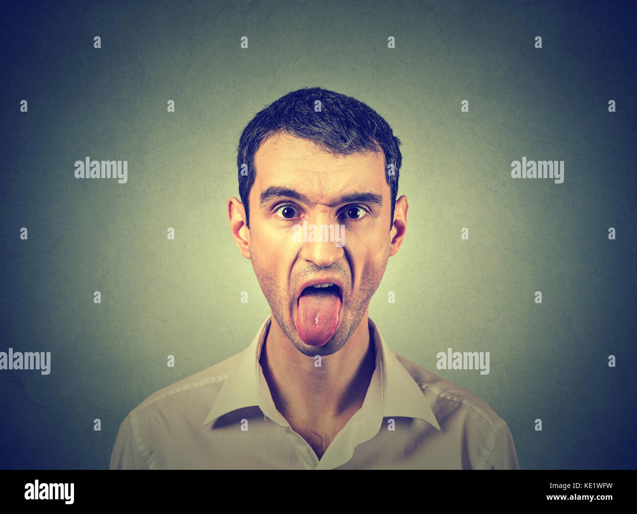 portrait of young man sticking out his tongue Stock Photo