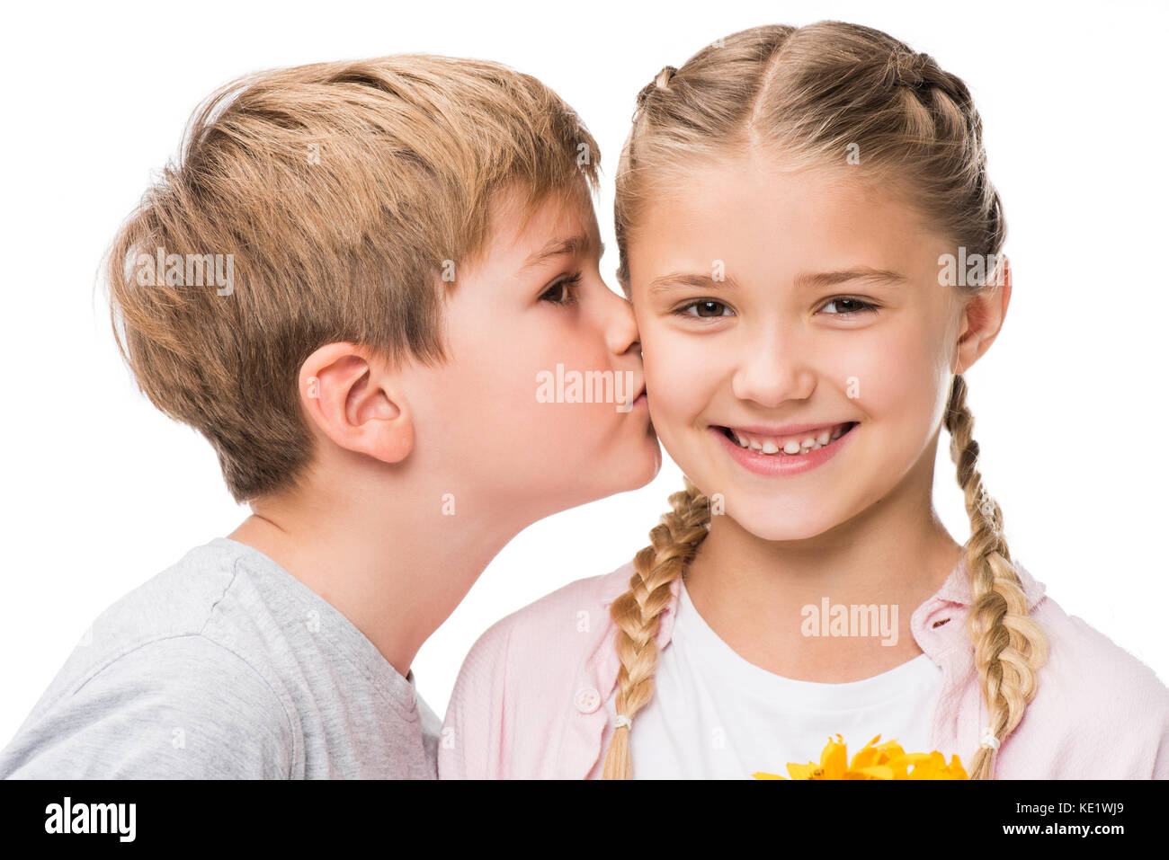 close-up portrait of cute little boy kissing happy girl isolated ...