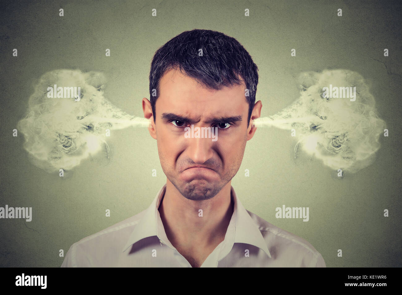 Closeup portrait of angry young man, blowing steam coming out of ears, about to have nervous atomic breakdown isolated gray background. Negative human Stock Photo