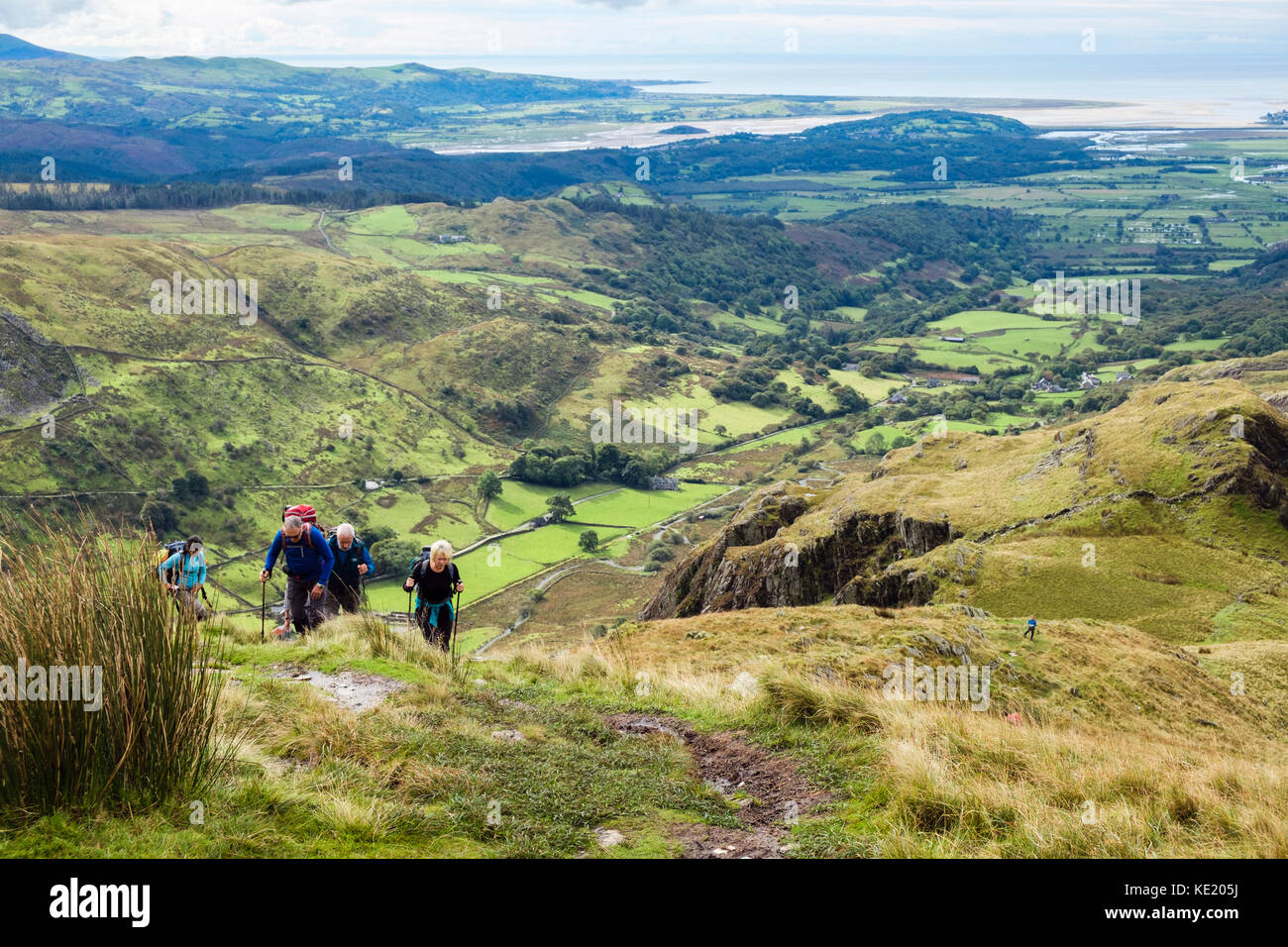 View to coast from south west ridge of Cnicht mountain with hikers hiking up from Croesor, Gwynedd, North Wales, UK, Britain, Europe. Stock Photo