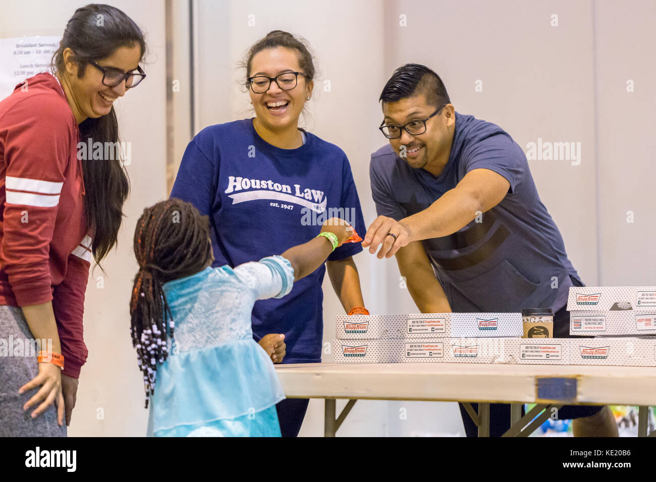 Torrential rain from Hurricane Harvey has caused record and catastrophic flooding in Houston. Support workers and volunteers play with a young girl Stock Photo