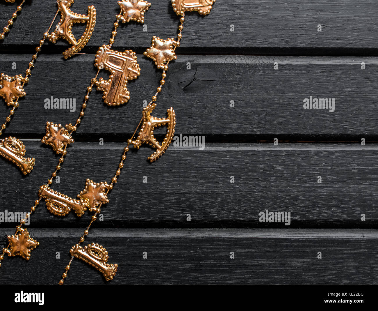 Christmas decoration background, on a black wooden backdrop,with chain showing reindeer, stars, train, trumpet, and christmas decor Stock Photo