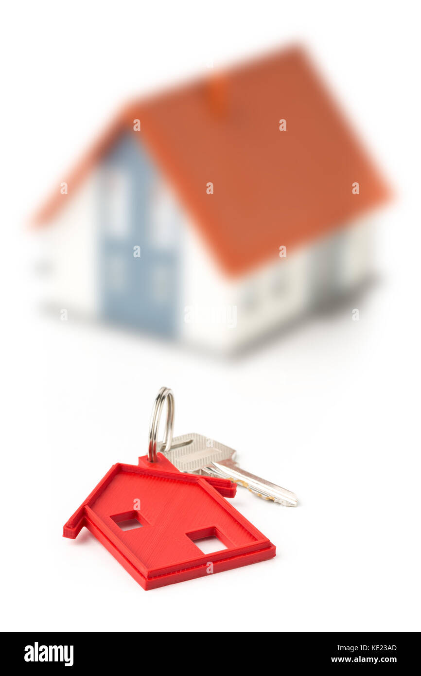 House door key with red house key chain pendant and model house over white background Stock Photo