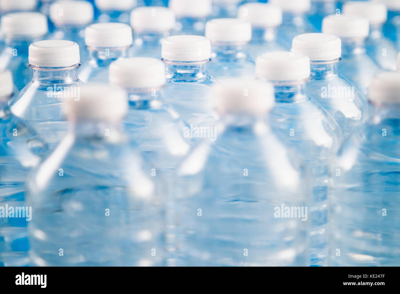 Side view of plastic water bottles in a row. Concept of factory