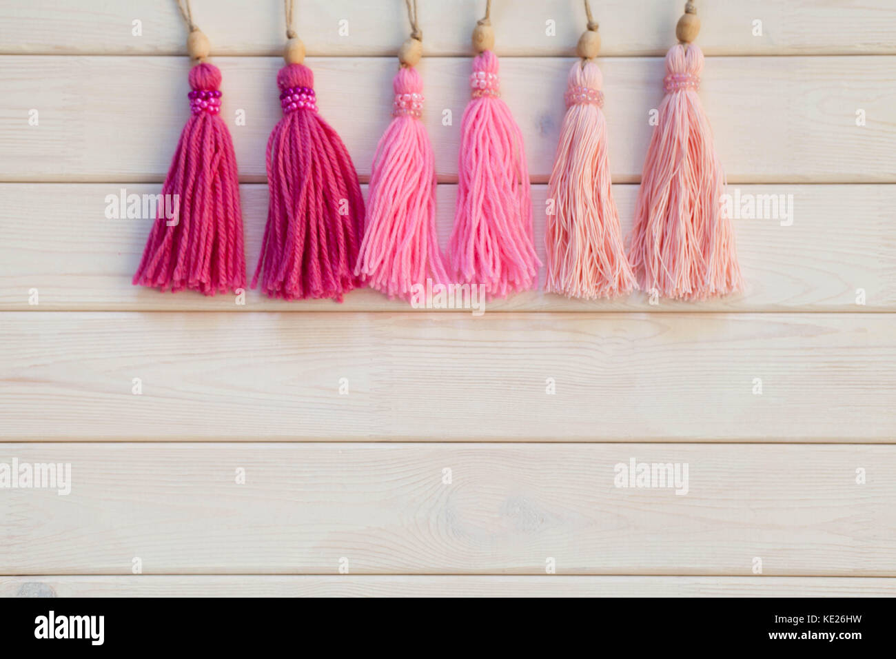 Pink tassels. Background of white wood. Stock Photo