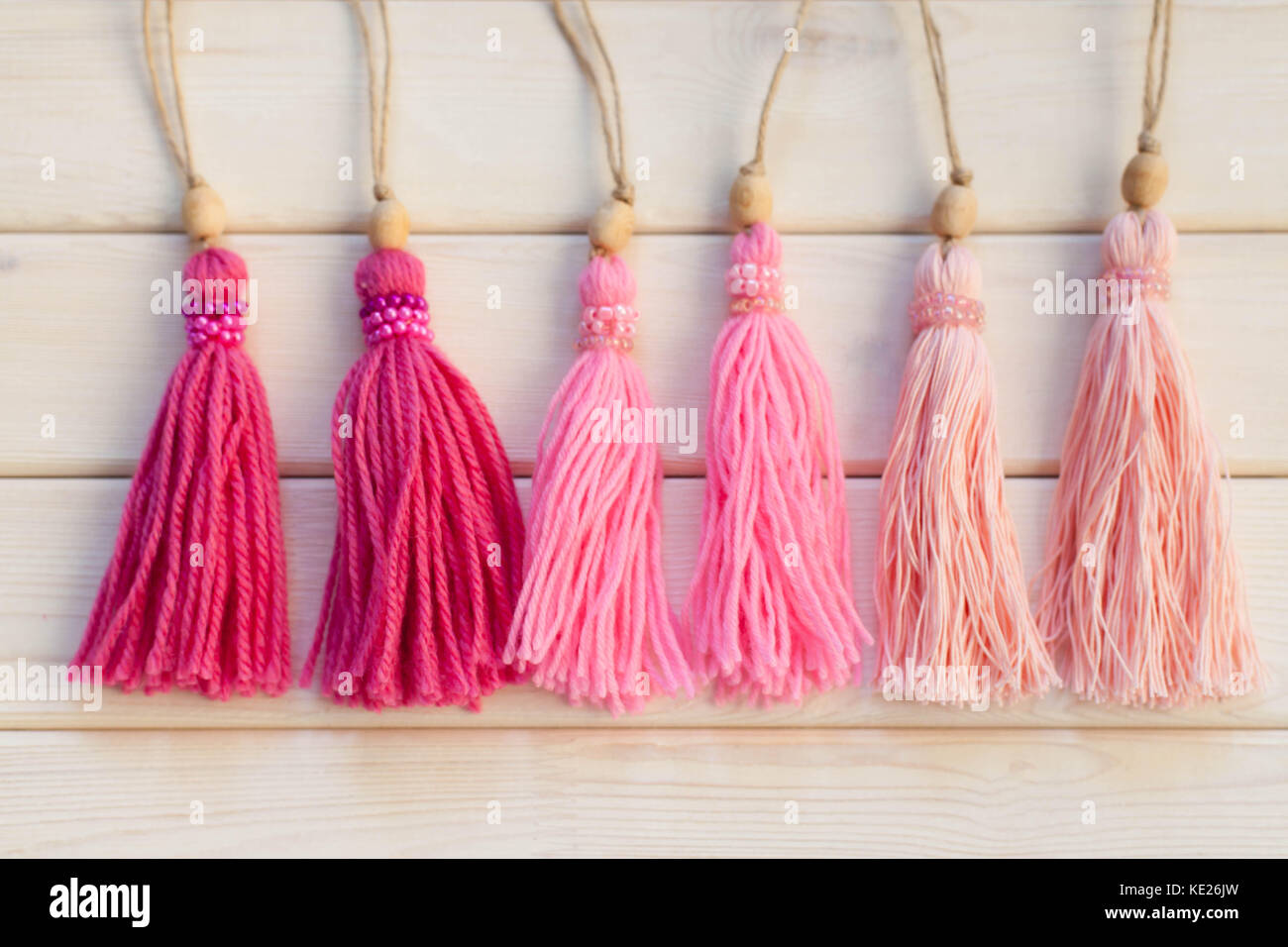 Pink tassels. Background of white wood. Stock Photo