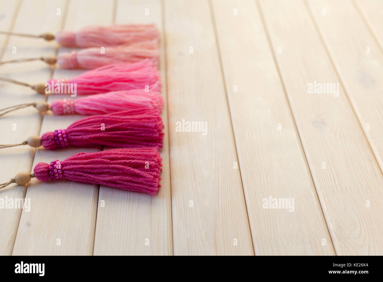 Pink tassels. Background of white wood. Stock Photo