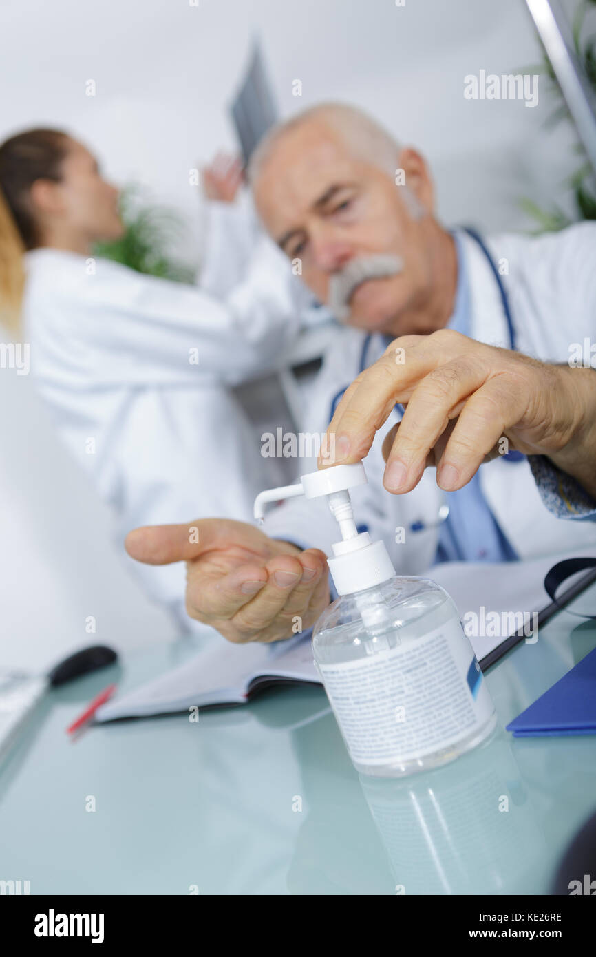 Doctor dispensing sanitiser into hand Stock Photo Alamy