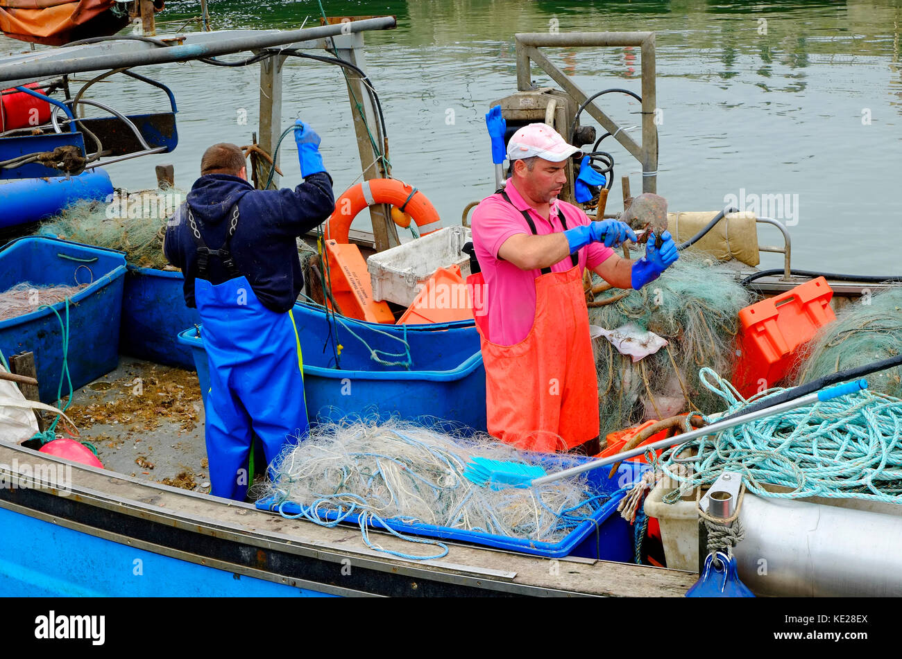Fishermen Working On Fishing Boat Deck West Bay Dorset England Stock Fishermen Working On Fishing Boat Deck West Bay Dorset England Stock