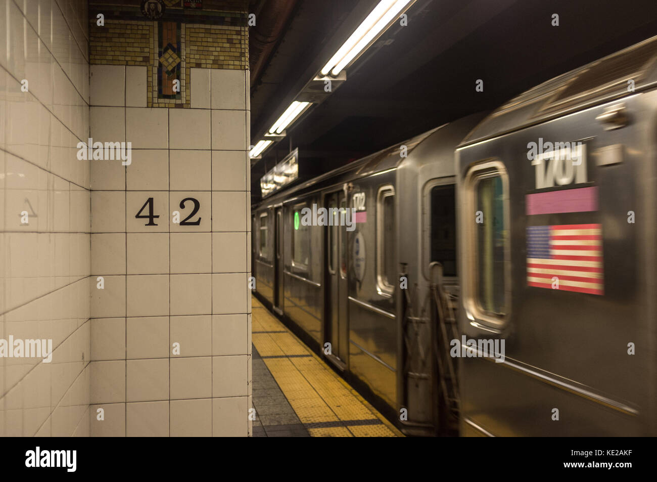 Subway train leaving station at platform at 42nd Street station, New