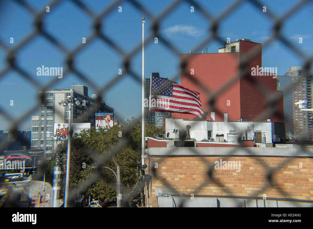 USA flag flying at half-mast on building in Hunters Point, Queens, New York City. Stock Photo