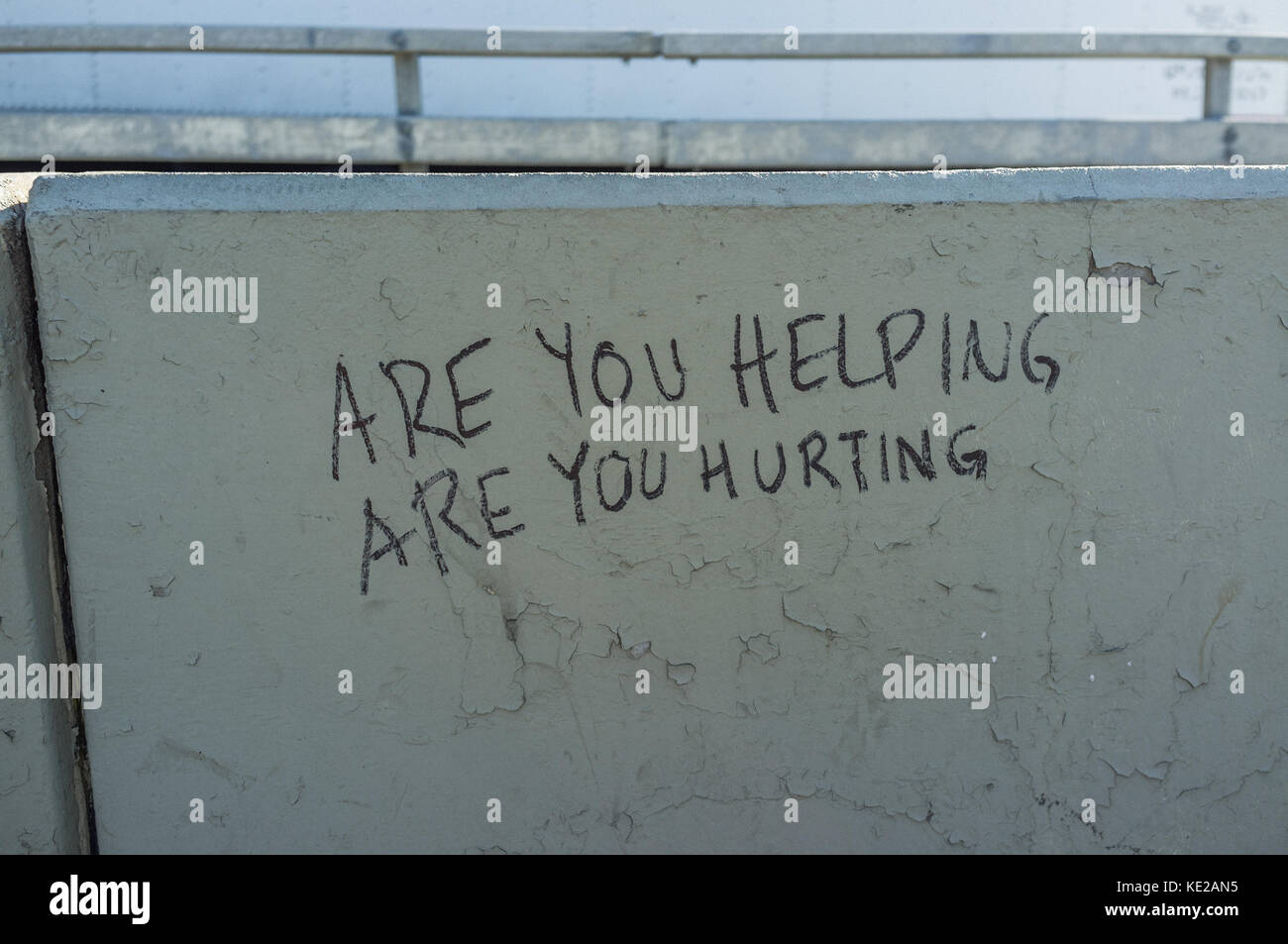 'Are You Helping Are You Hurting' written in marker pen on the Pulaski Bridge, New York City. Stock Photo