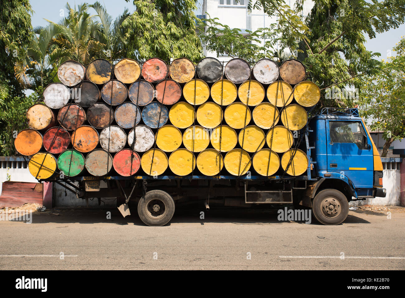 Truck loaded with empty yellow and colorful oil barrels in Kochi, South India. Stock Photo